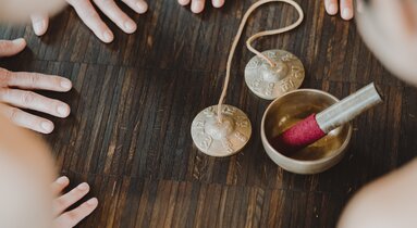 die Hände der Yoginis umringen eine Klangschale | © TVB Wipptal | Johannes Bitter