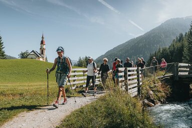 Eine Wandergruppe wird von einer Wanderführerin in Obernberg geführt | © TVB Wipptal | Johannes Bitter