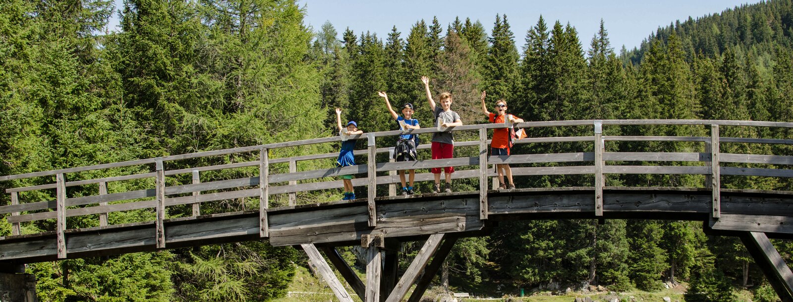 Kinder winken von einer Holzbrücke aus | © TVB Wipptal | Joakim Strickner
