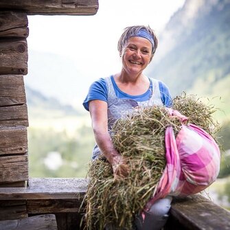 Helga Hager mit Heu in Hand auf der Alm im Valsertal | © TVB Wipptal